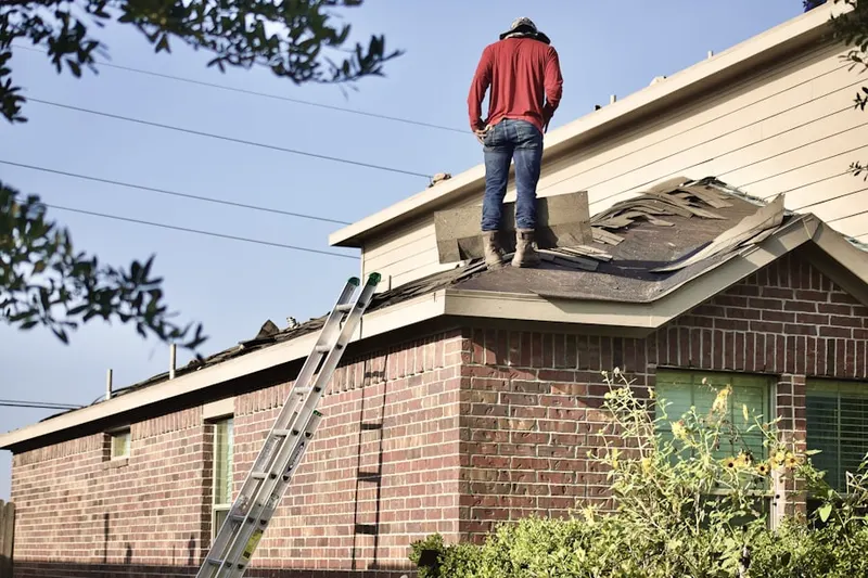 Professional roofer working on a residential roof in Lake George Park